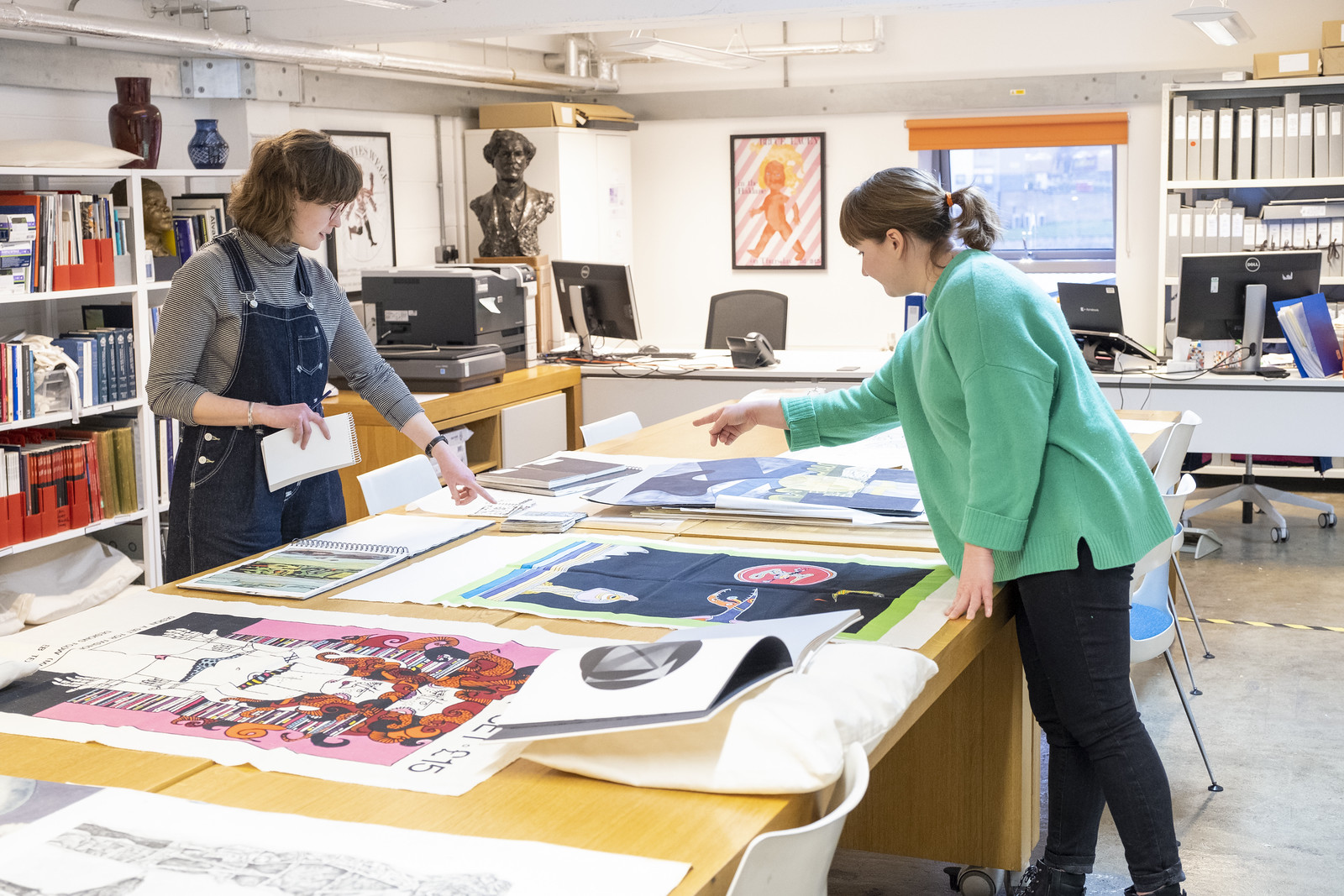 Two people handling large-format material in the GSA Archives workspace