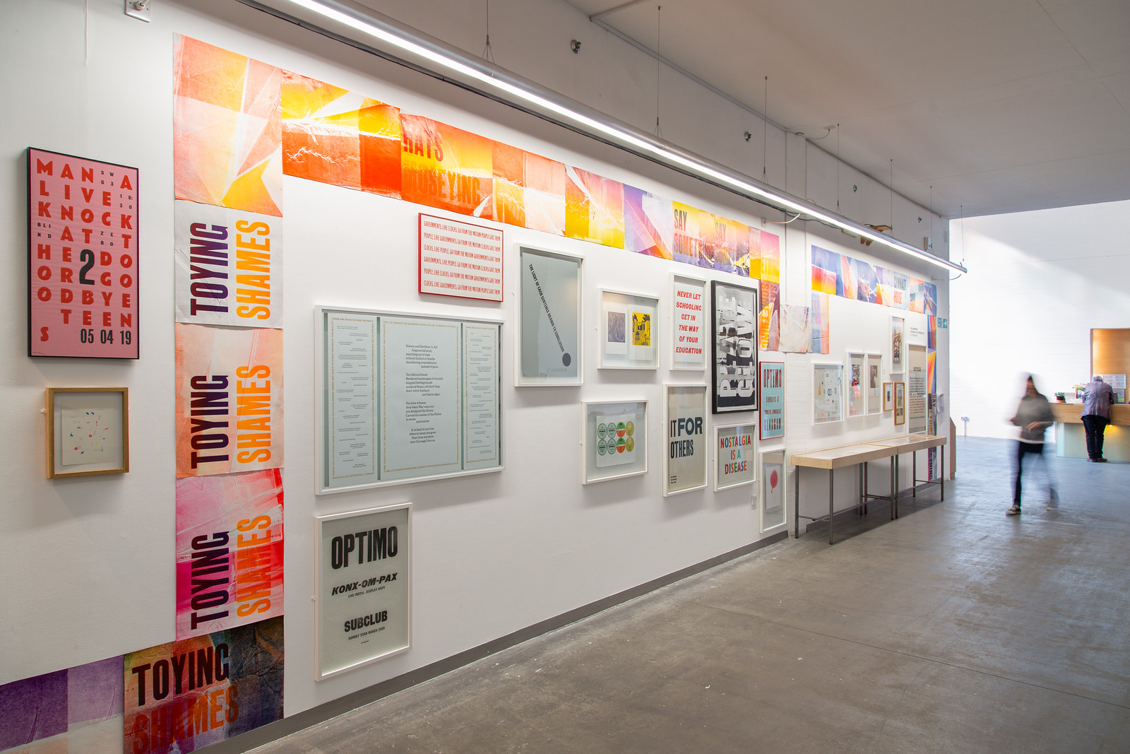 A long gallery wall filled with colourful letterpress work