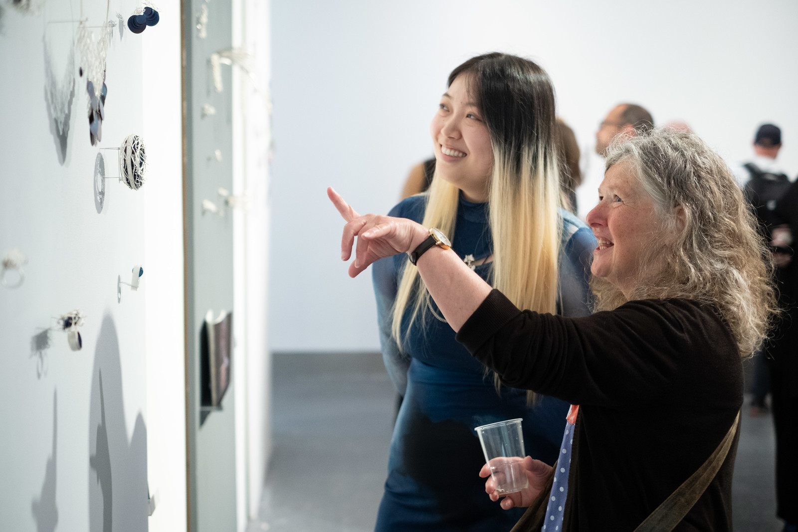 Two visitors looking at student work in the Reid Building