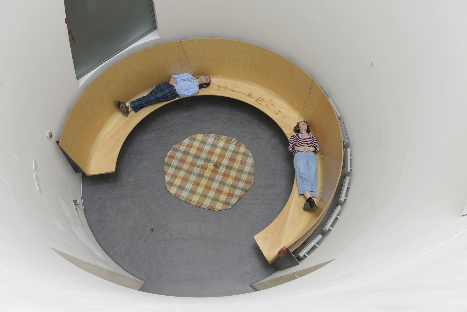 Two people resting within a curved circular installation