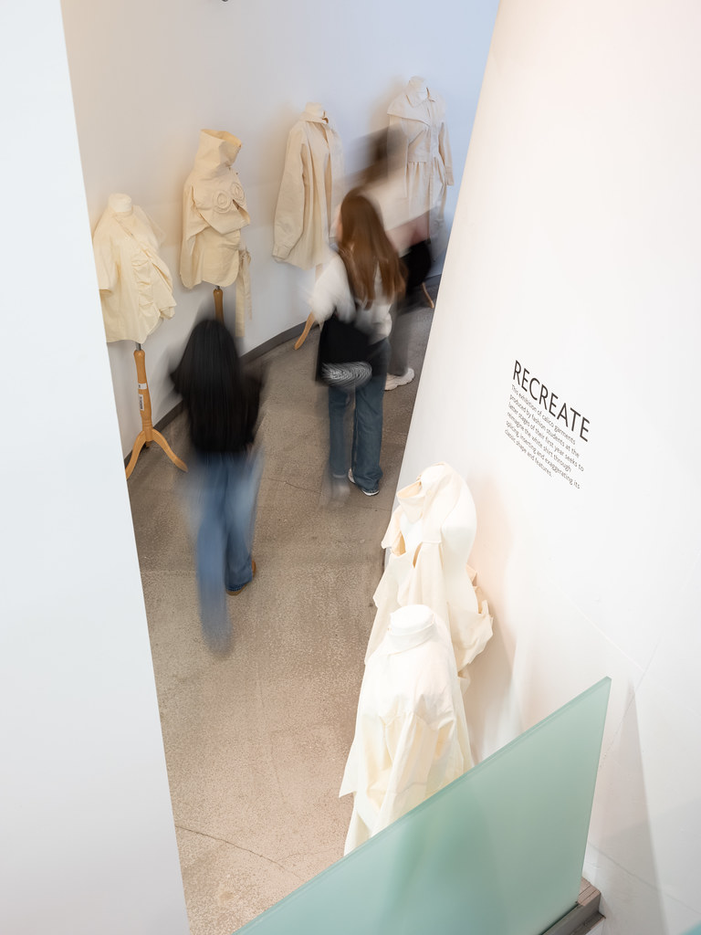 Visitors moving through a bright exhibition space