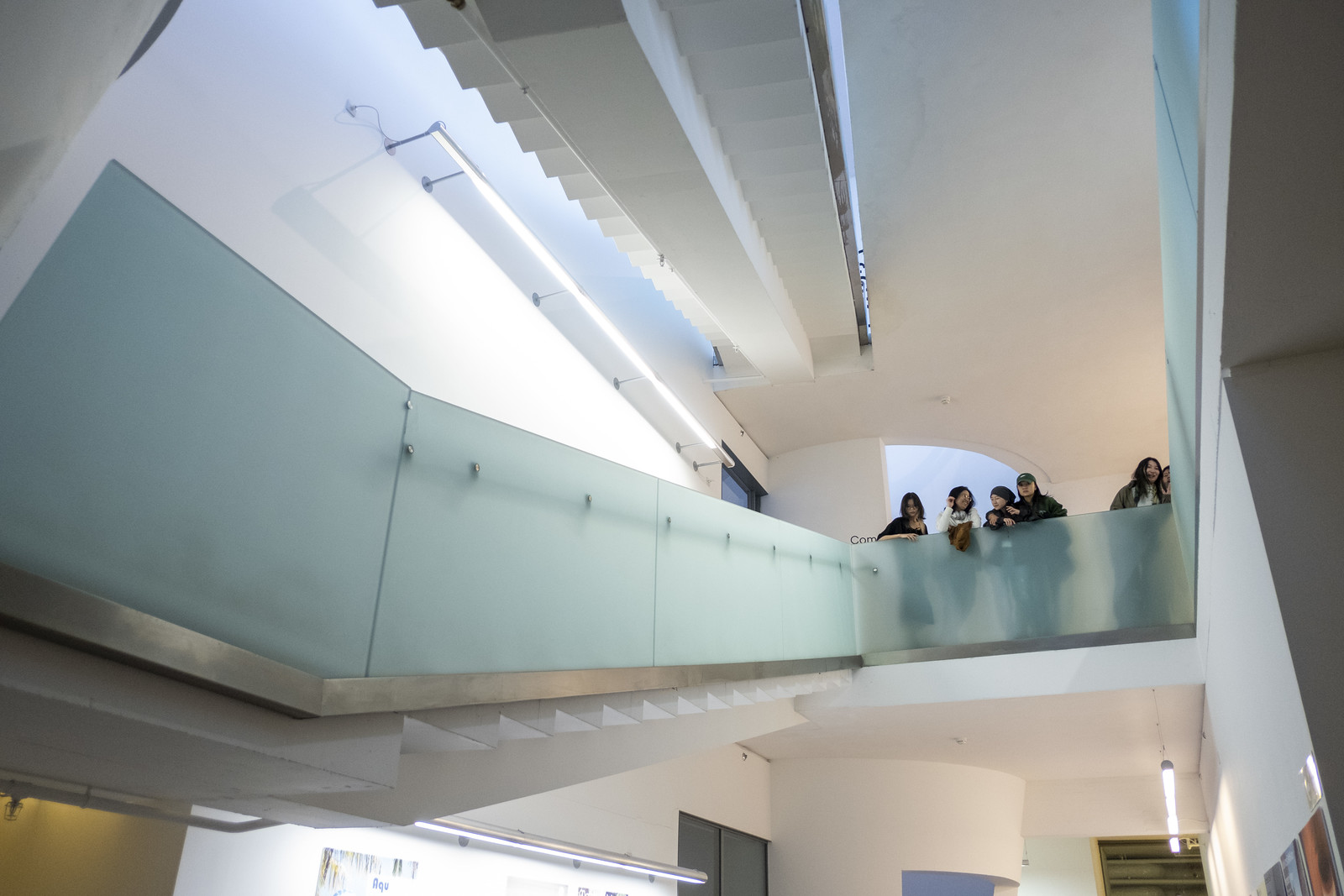 Visitors crossing an interior walkway at the Postgraduate Degree Show