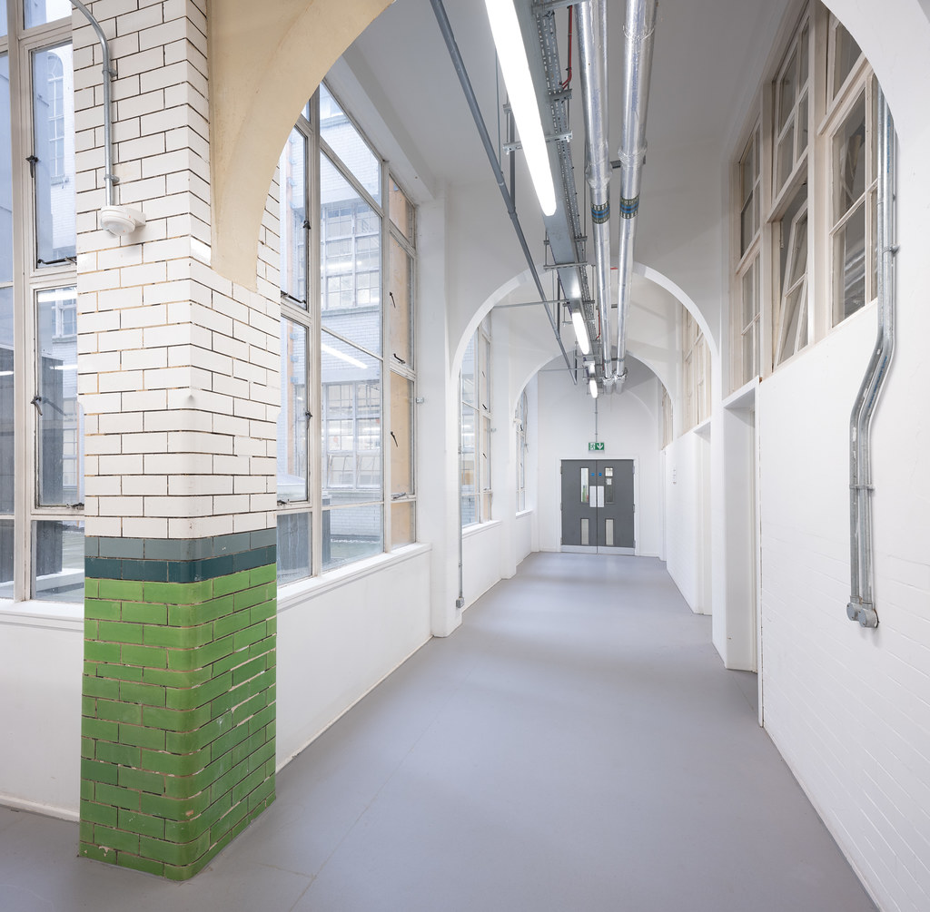 Bright studio corridor with white brick arches
